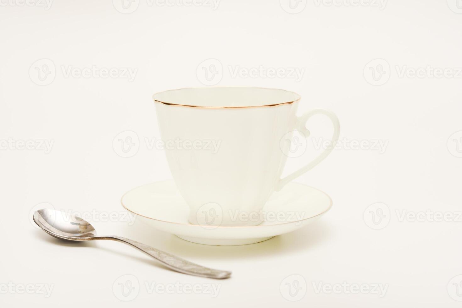 Tea pair on a white background. A cup and saucer with a spoon. photo