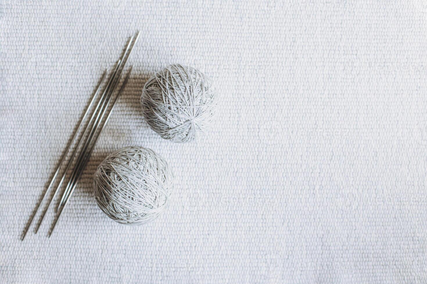 Balls of wool yarn and needles for hand knitting on a grey background. Concept for handmade. photo