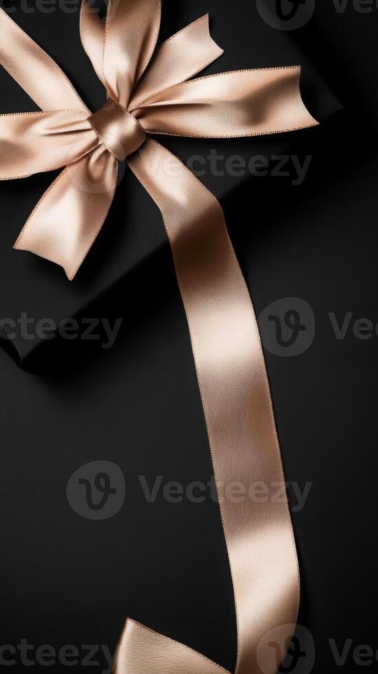 A black background with a ribbon bow elegantly tied and placed in the upper corner, creating a luxurious gift feel with empty space photo