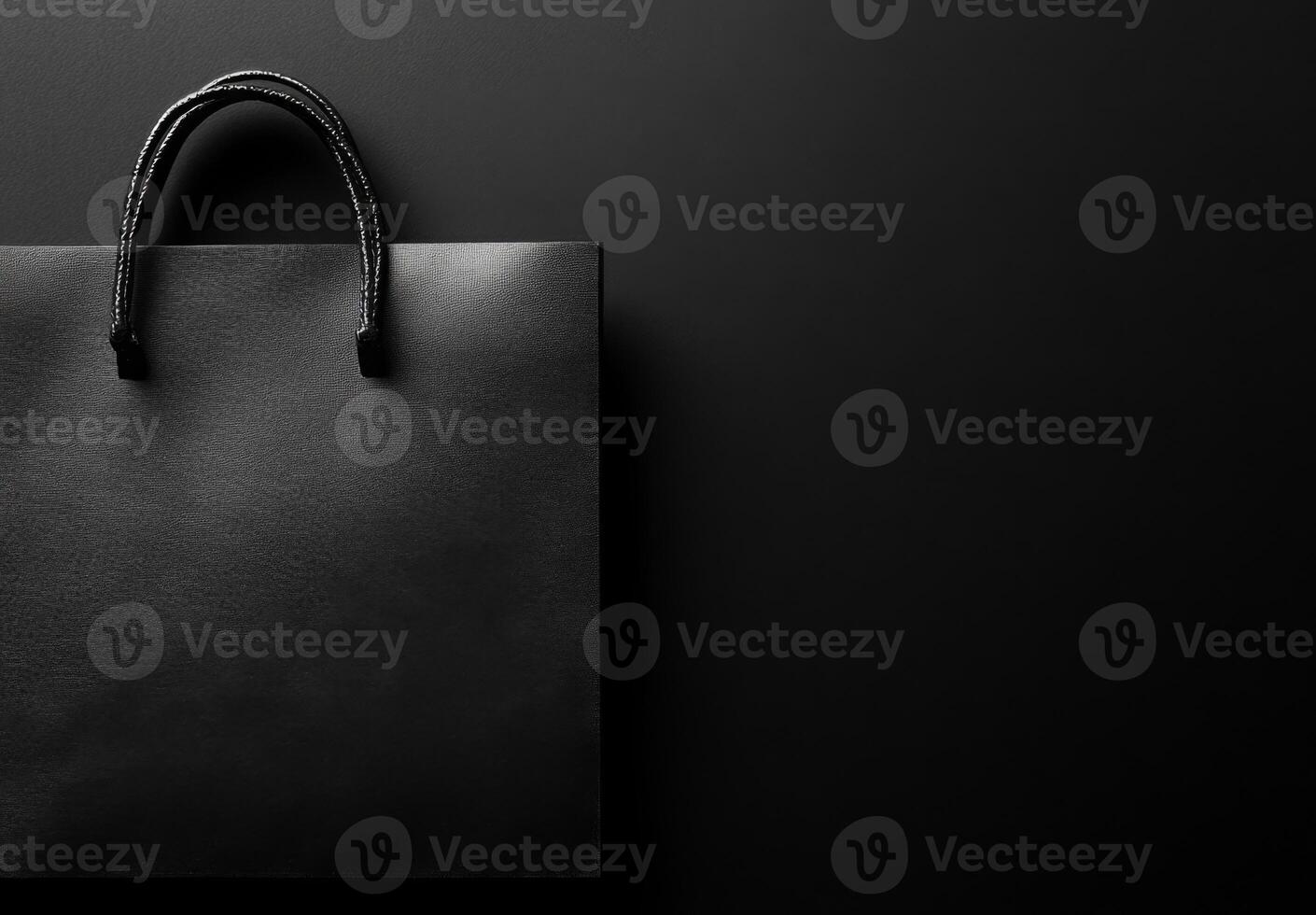 A black background with a subtle texture and the shadow of a shopping bag, leaving plenty of room for copy space photo