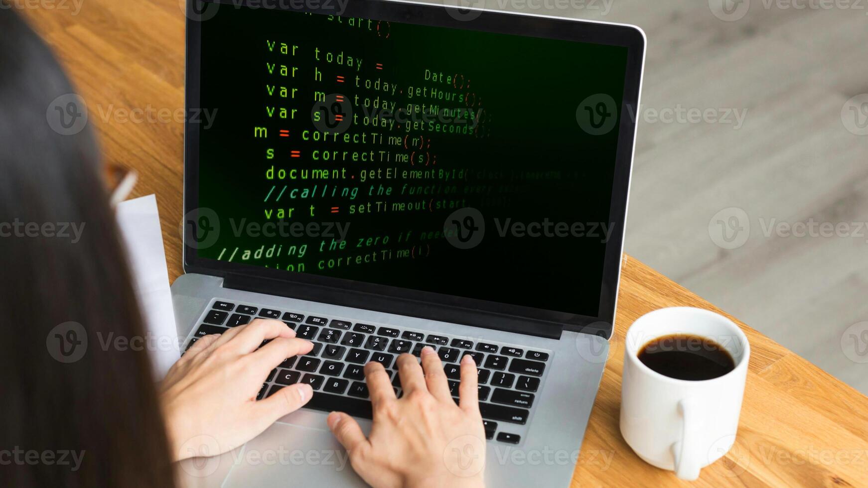 A woman typing on a laptop with code on the screen photo