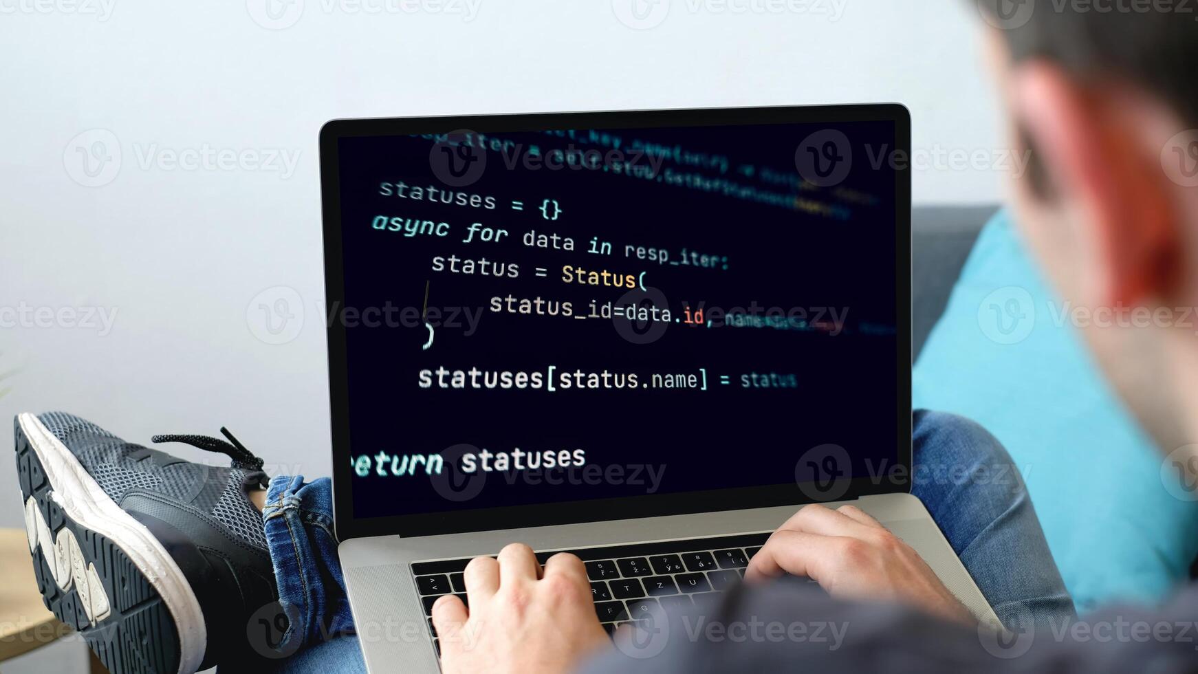 A man using a laptop with a programming code on it photo