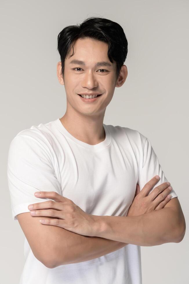Portrait of young smiling asian man over white background photo