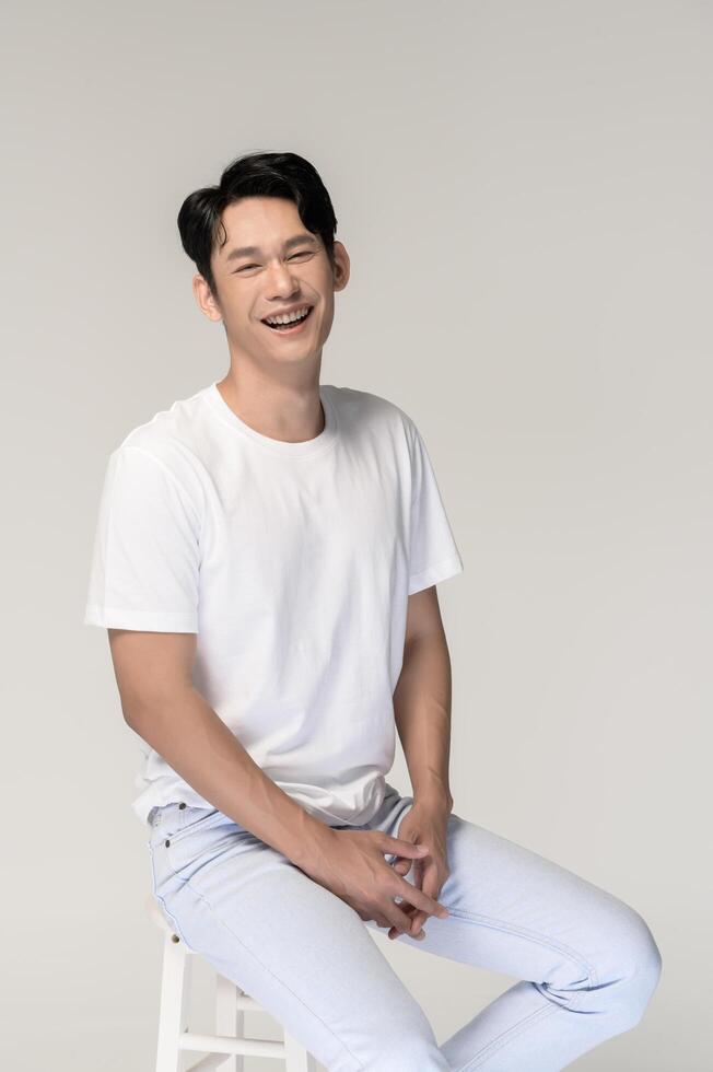 Portrait of young smiling asian man over white background photo
