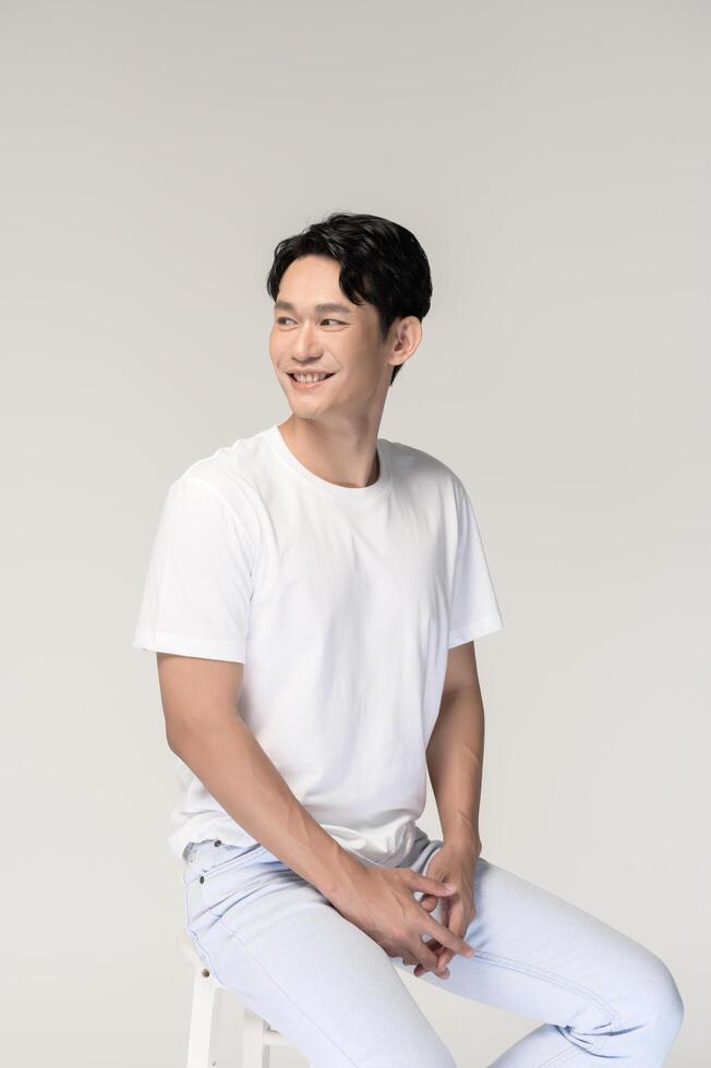 Portrait of young smiling asian man over white background photo