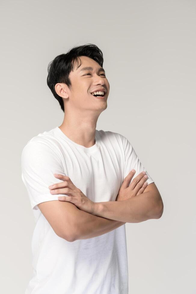 Portrait of young smiling asian man over white background photo