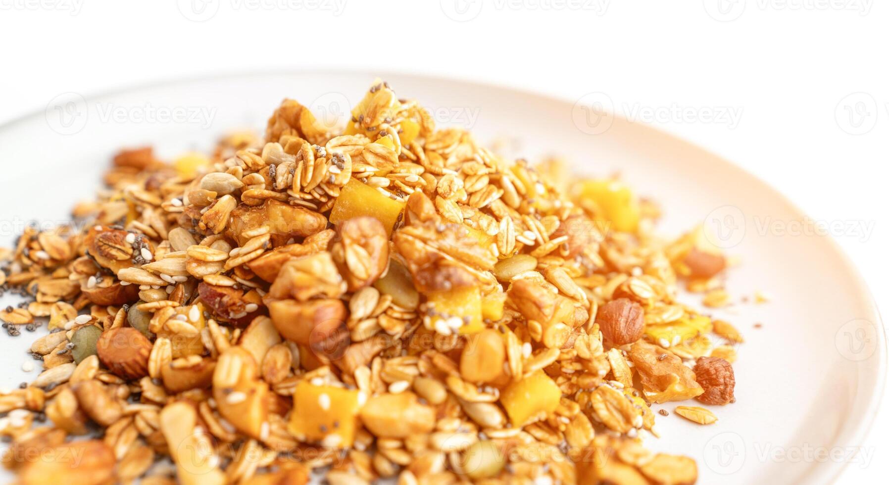 A bowl of granola with nuts and seeds on a white plate. The granola is a mix of different types of grains and nuts, and it looks like a healthy snack. photo