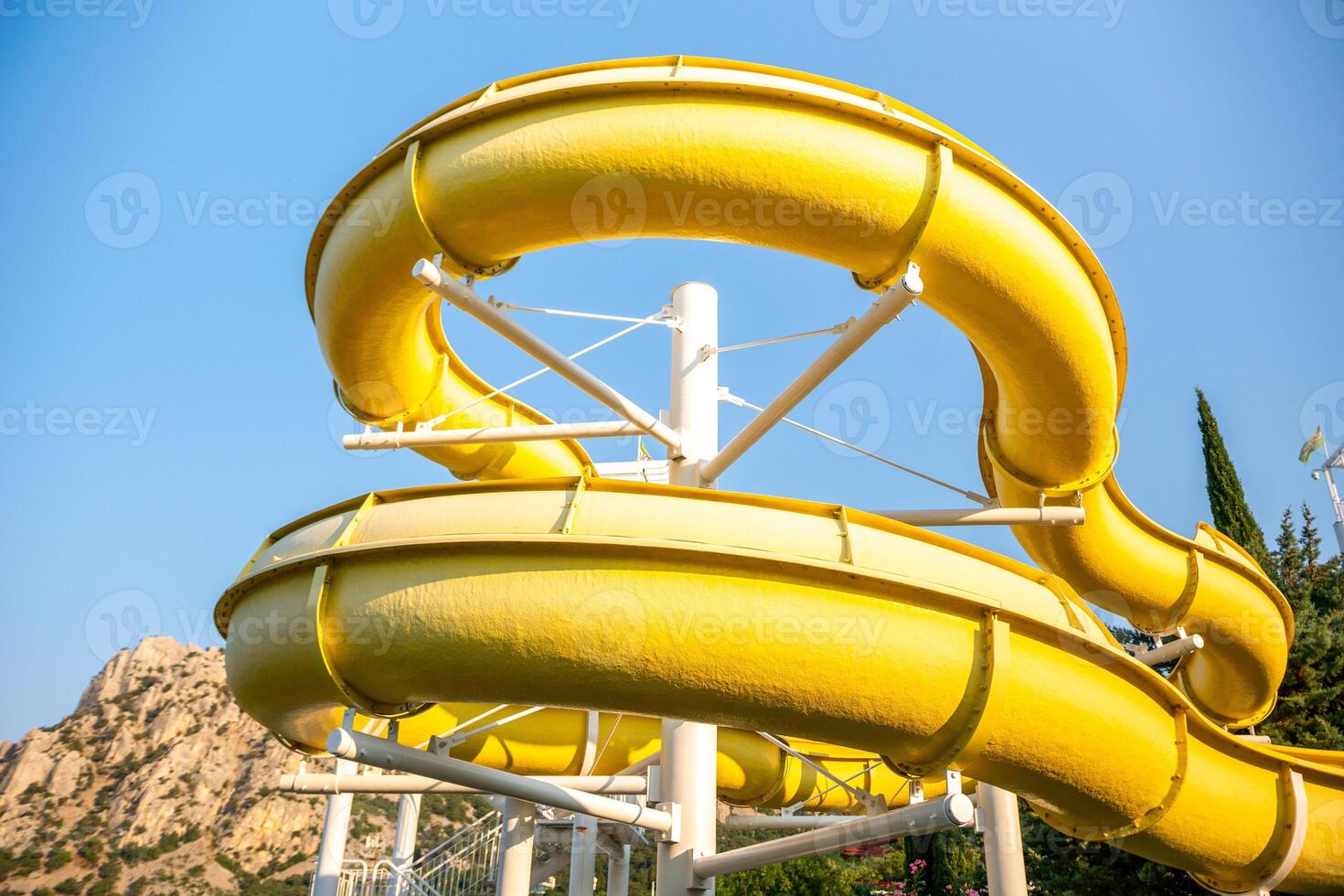 Water Slide, Amusement Park, Summer Fun - A yellow water slide curves through the air, offering a thrilling ride for visitors at an amusement park. photo