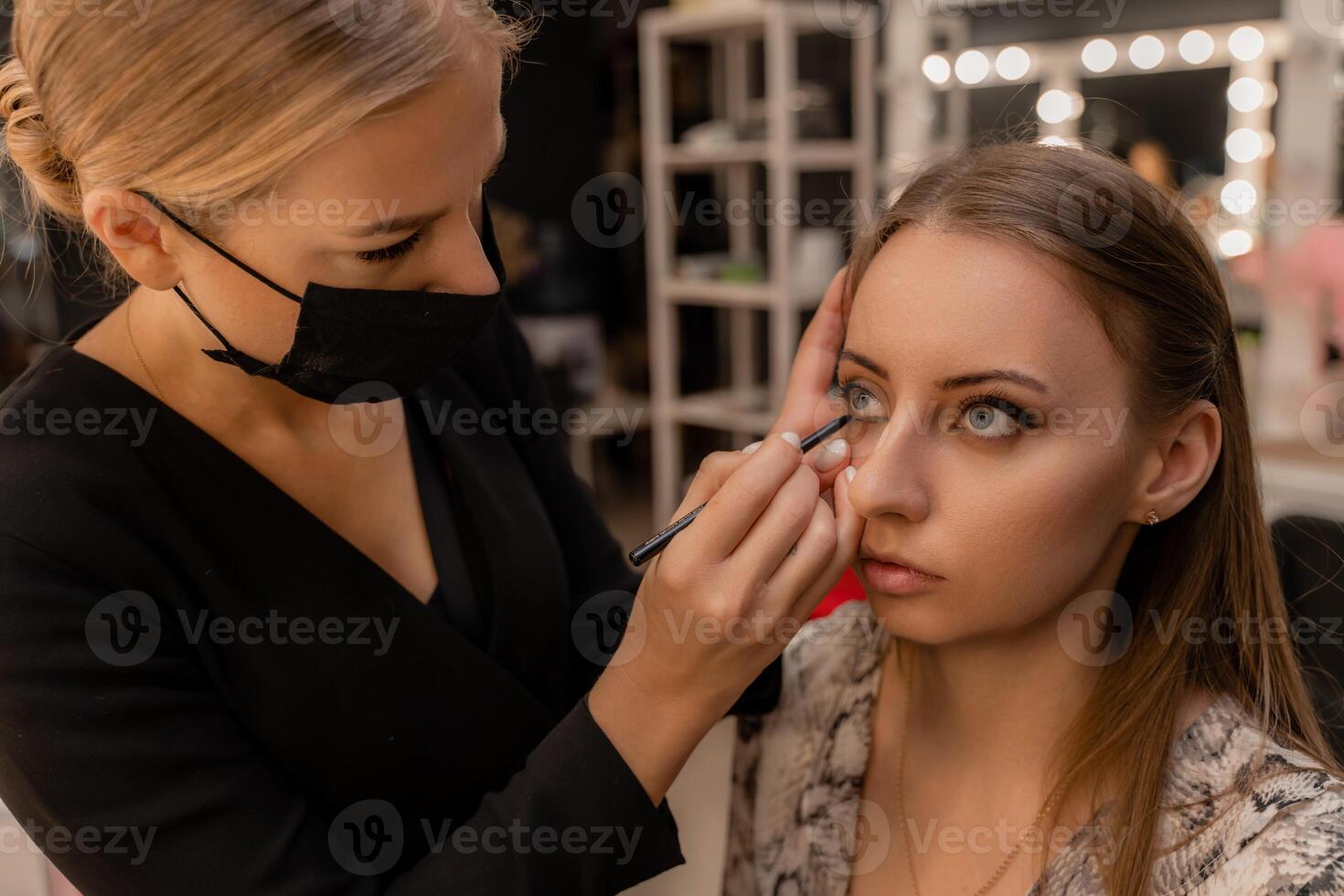 Make-up artist working with brush on model eyes Close up of applying make up on young girl,semi profile, professional make up in beauty studio photo