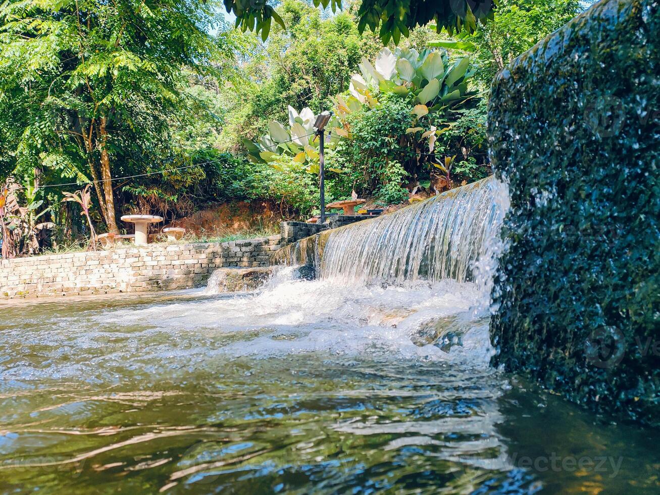 Beautiful small streams flow through a resort, offering a picturesque view at Kemensah. This recreation spot is a must-visit tourist attraction for nature enthusiasts. photo