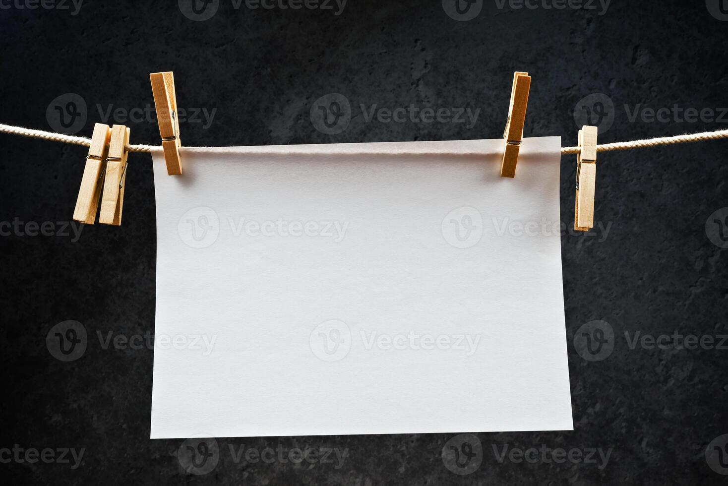 Blank note paper hanging on rope with clothes pins photo