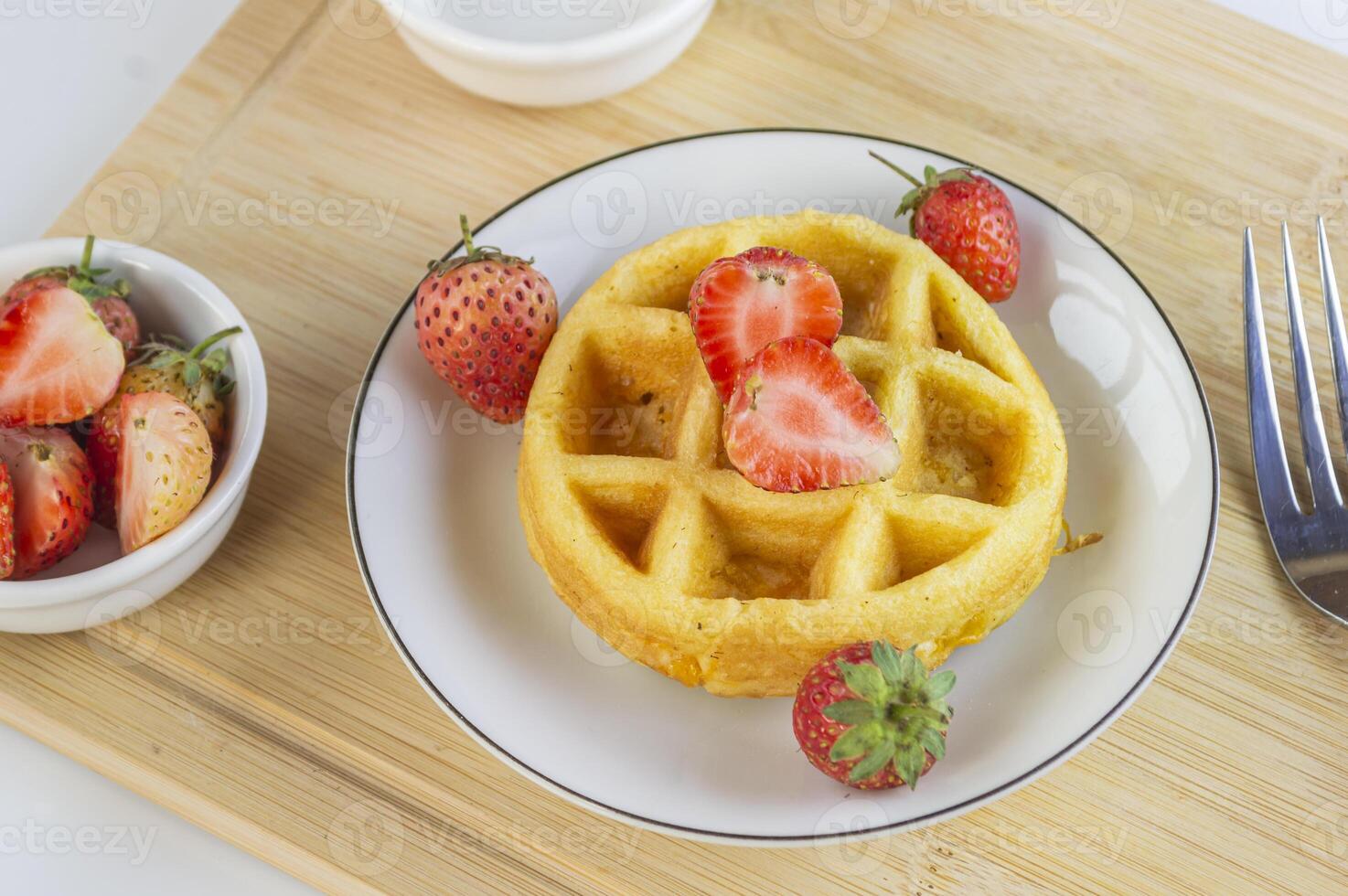 a waffle with strawberries on a plate photo