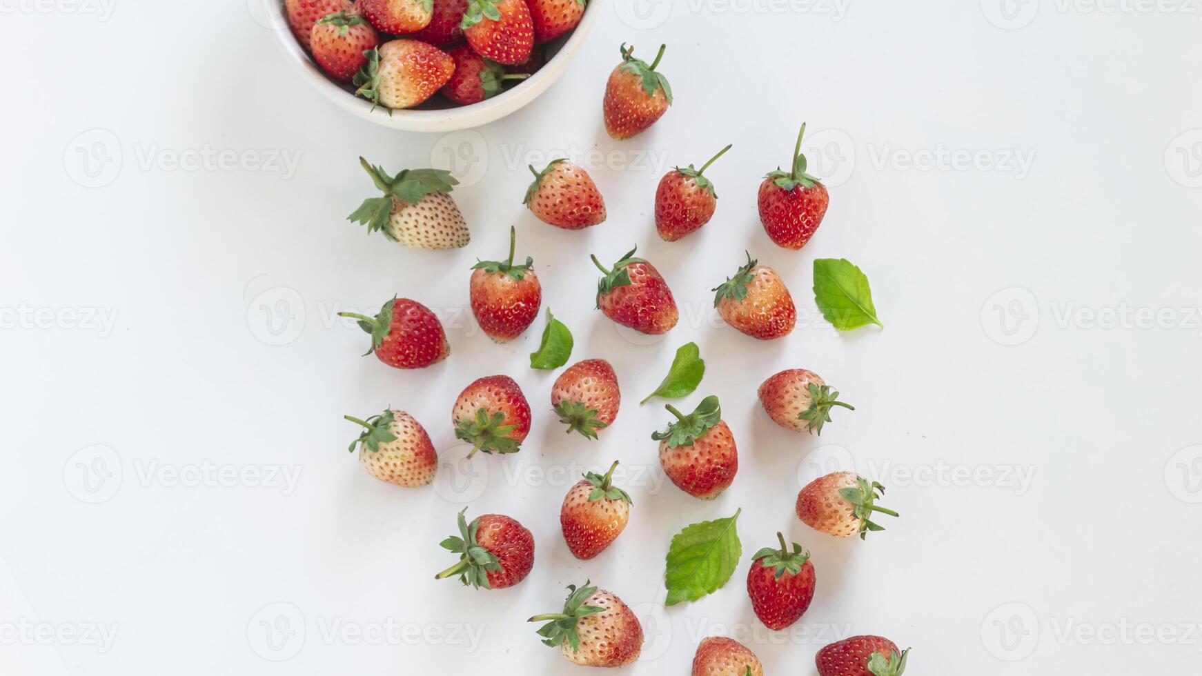 a bowl of strawberries on a white surface photo