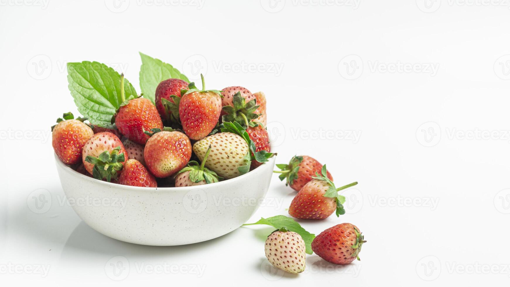a bowl of strawberries on a white surface photo