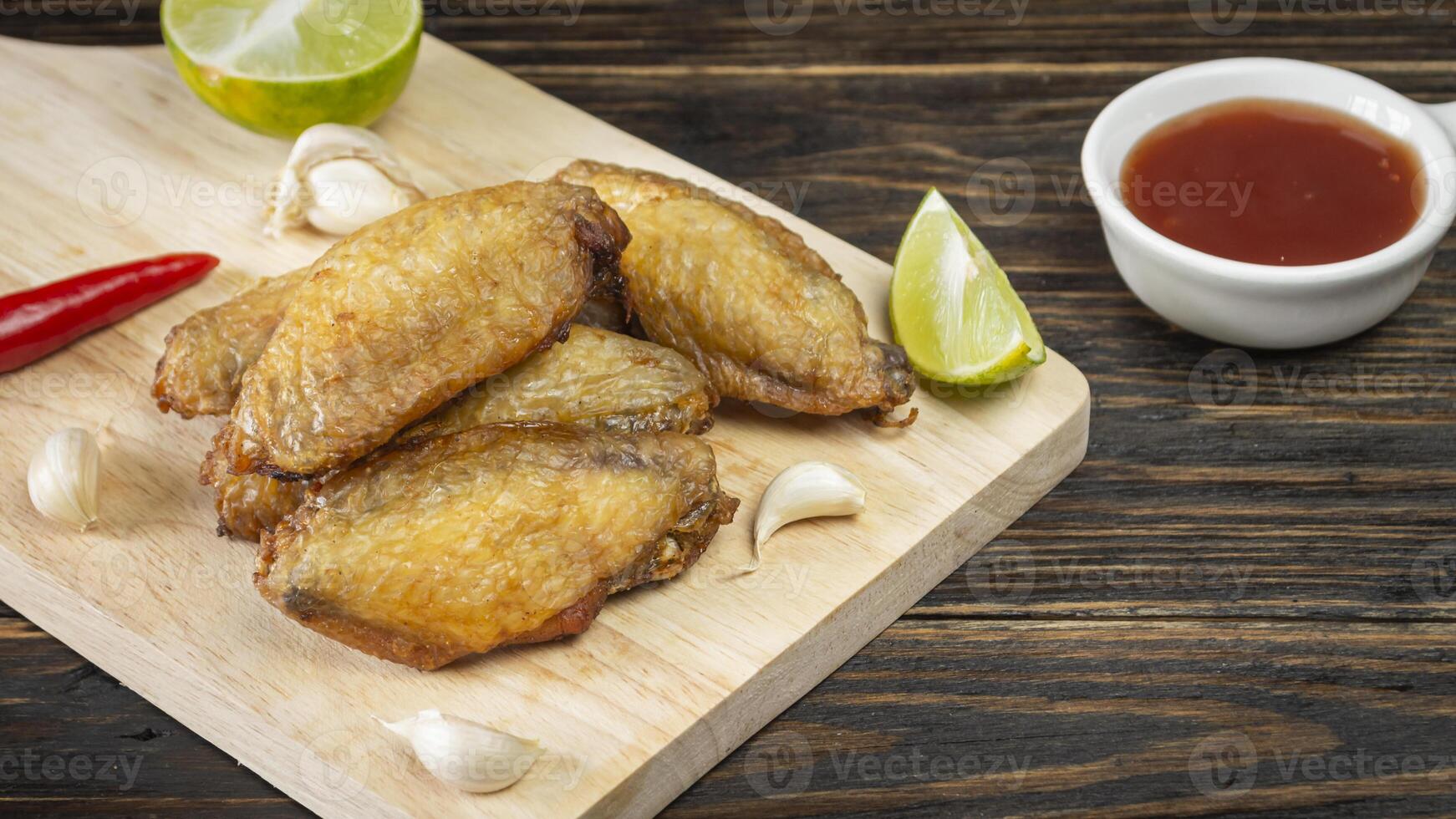 chicken wings with sauce and lettuce on a cutting board photo