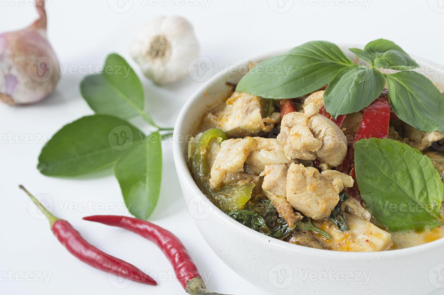 a bowl of chicken green curry with peppers and herbs photo