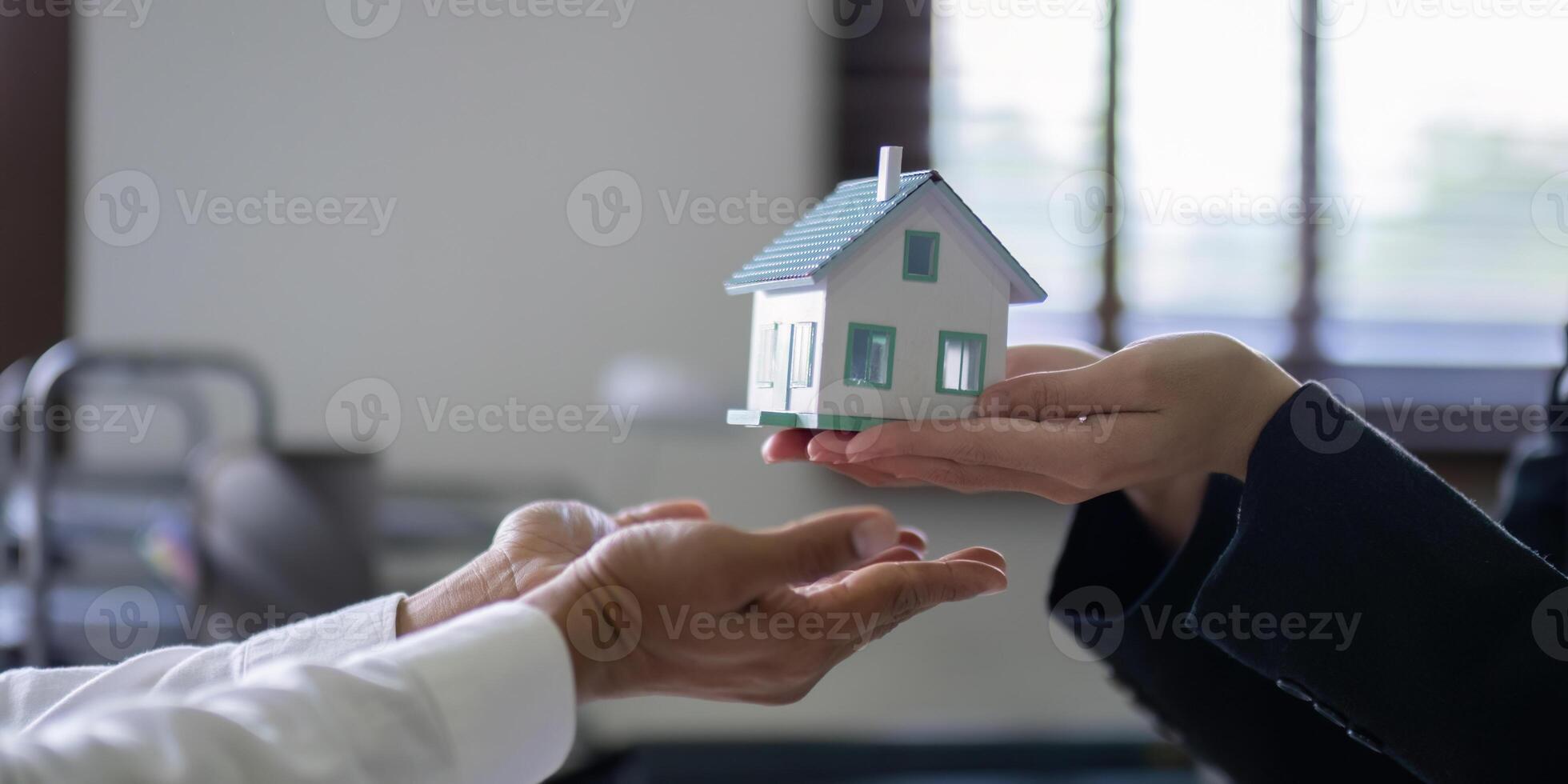 Hands Exchanging House Model in Real Estate Negotiation photo