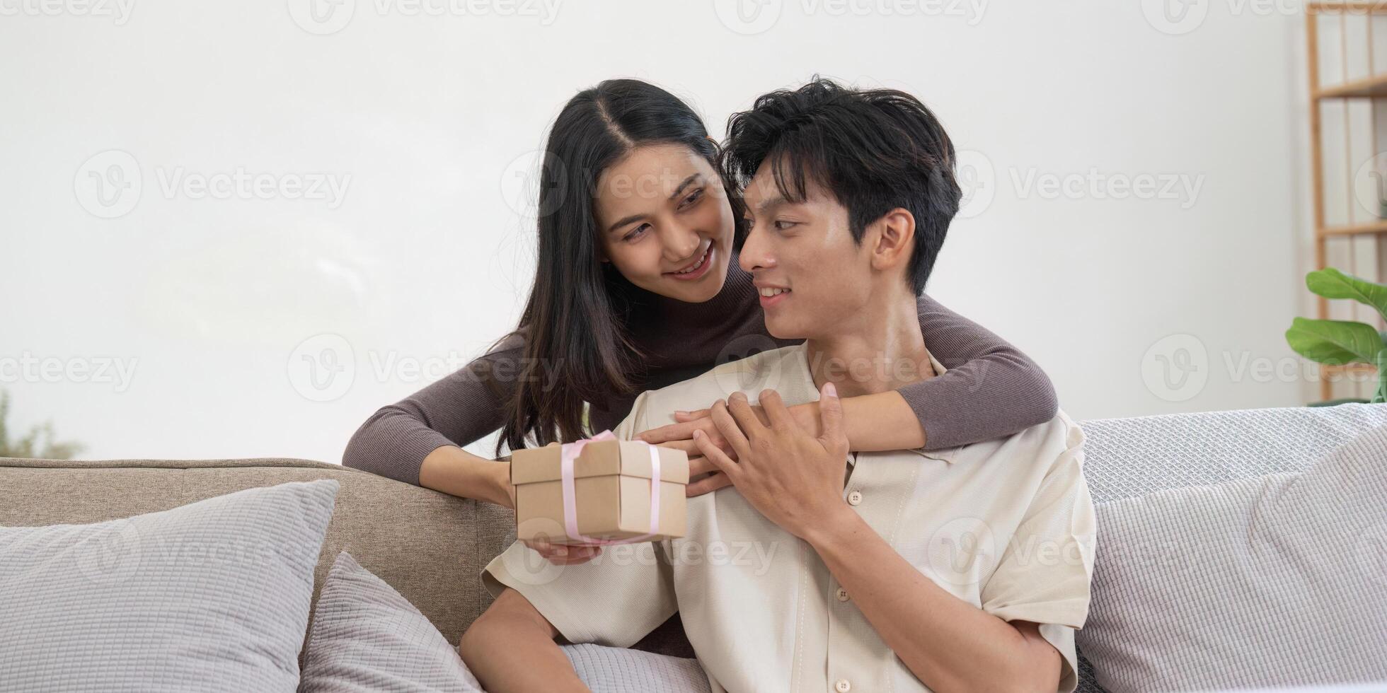 Young couple exchanging a thoughtful gift at home photo