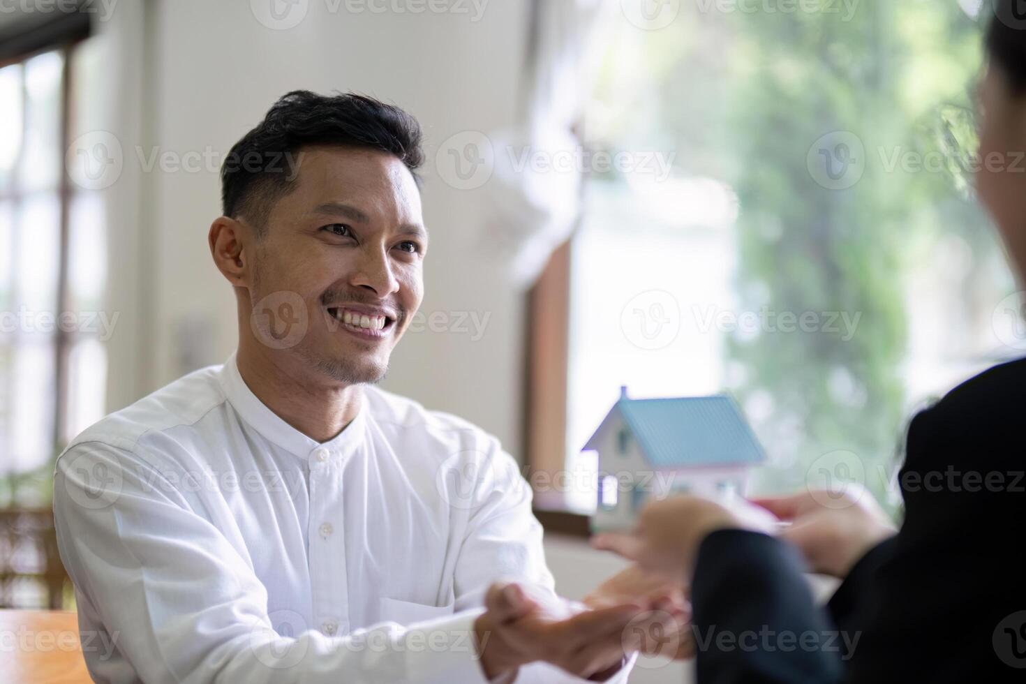 Potential Homebuyer Receiving House Model from Real Estate Agent photo