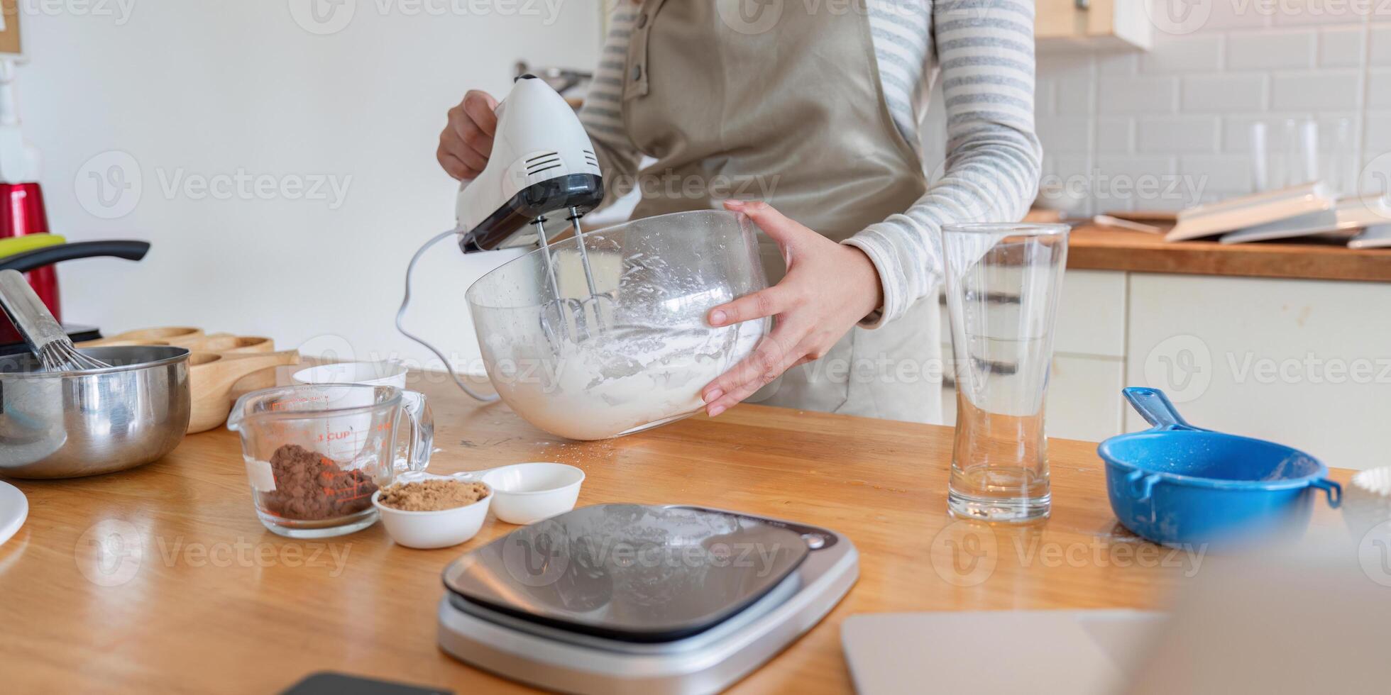 Woman Preparing Dessert with Mixer in Modern Kitchen photo