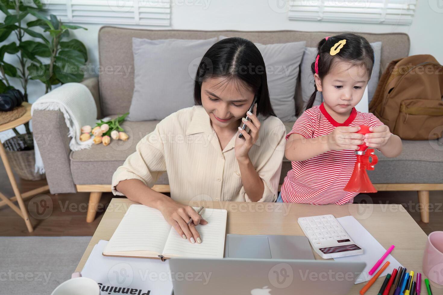 Multitasking Mother on Call While Child Plays Nearby photo