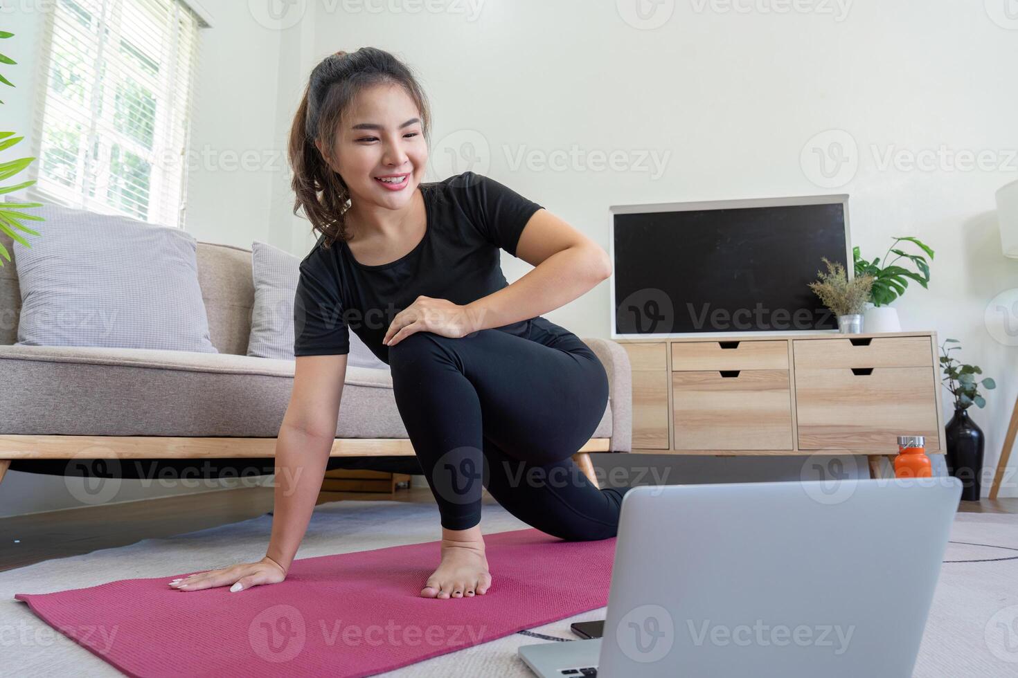 Woman Engaging in Virtual Yoga Session at Home photo