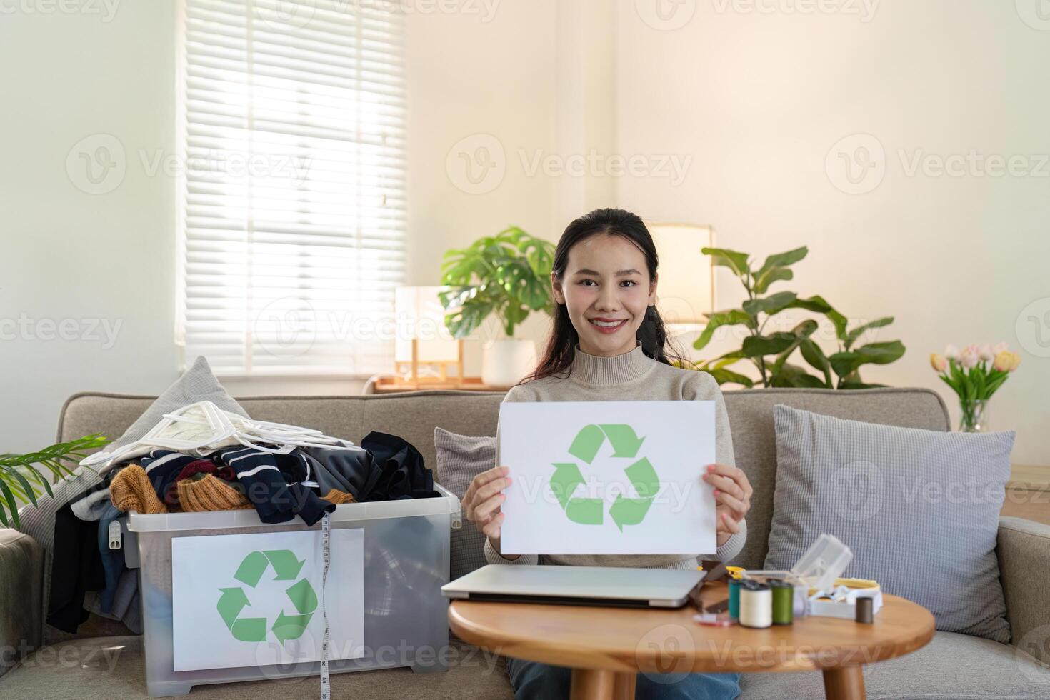 Woman Displaying Recycling Sign with Clothing Bin. Promoting Sustainable Practices photo