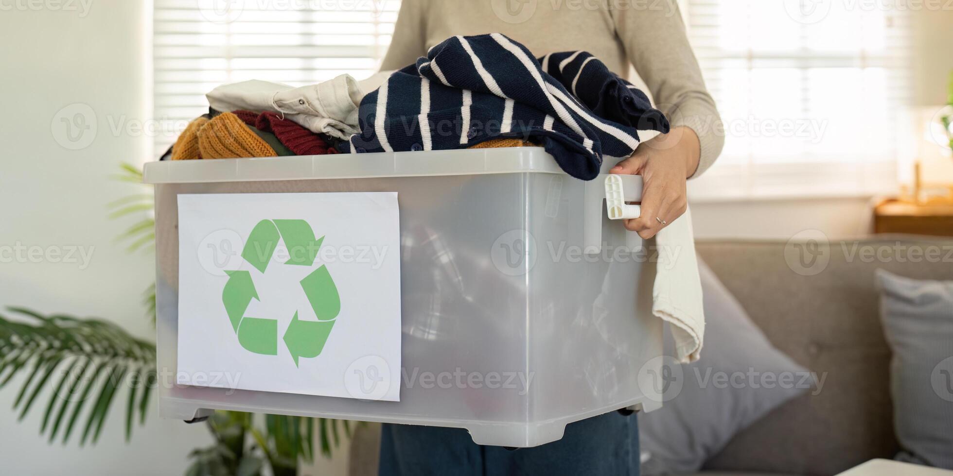 Woman Holding Recycled Clothing Bin. Sustainable Fashion and Recycling photo