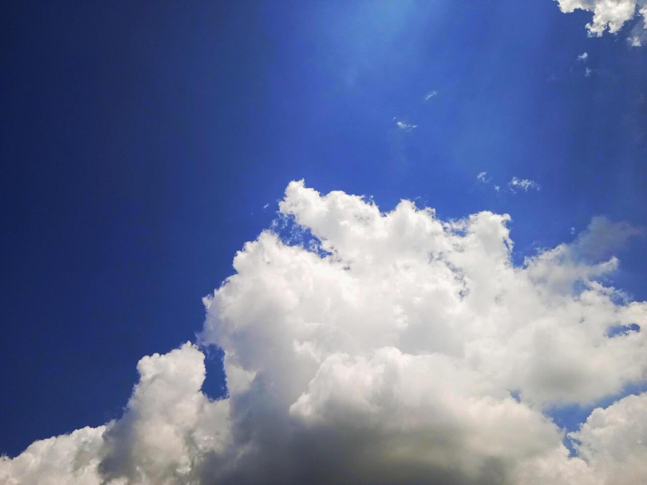 A blue sky with clouds and a plane flying in it photo