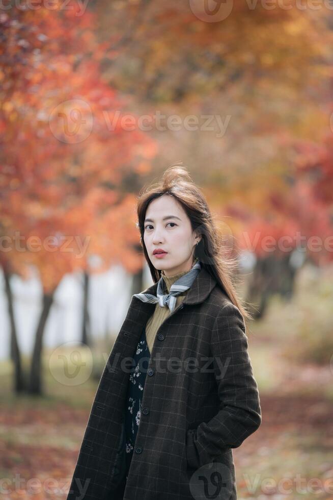 retrato de un joven asiático mujer con otoño hojas foto