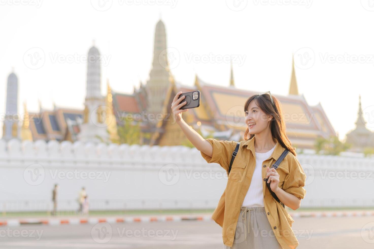 Traveler asian woman in her 30s explores the Grand Palace with a local guide. Uncover hidden gems and immerse yourself in Thai culture with her adventure. photo