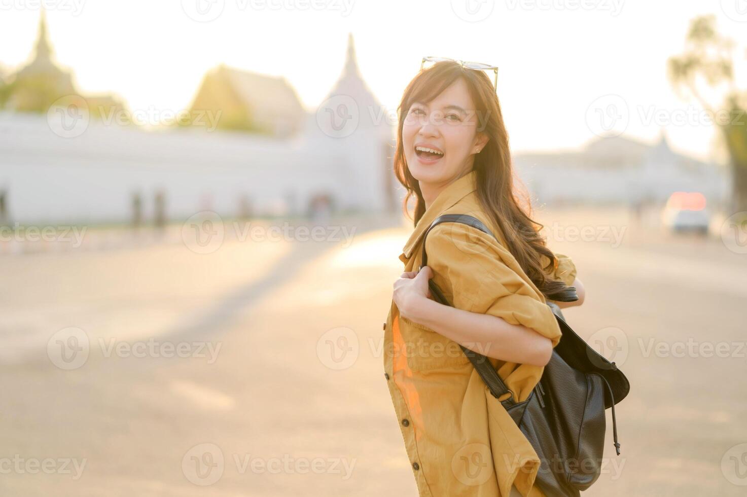 Traveler asian woman in her 30s stands bathed in the golden glow of sunset, embracing the freedom of exploration. on summer holiday weekend vacation trip in Bangkok, Thailand photo