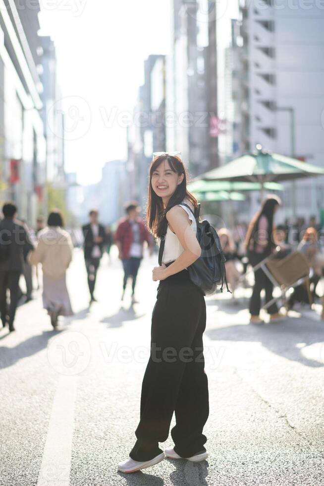 Embrace the energy of Tokyo, a young Japanese businesswoman with a positive outlook in the bustling urban scene. photo