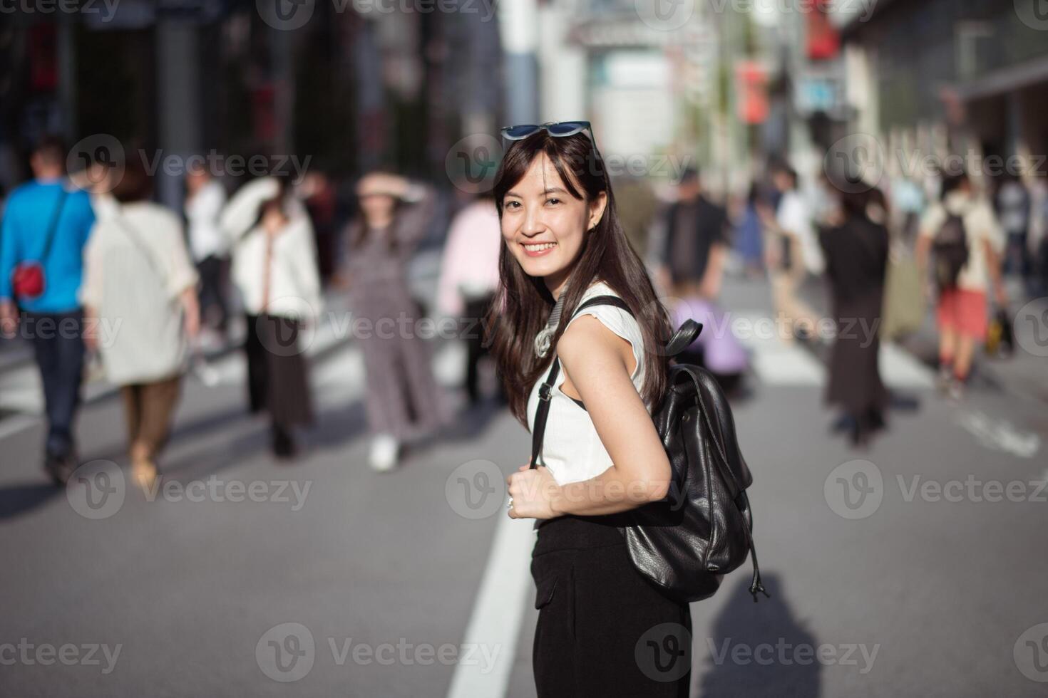 City stroll, Confident Japanese businesswoman in her 30s enjoying a refreshing walk in the vibrant urban landscape of Tokyo. photo