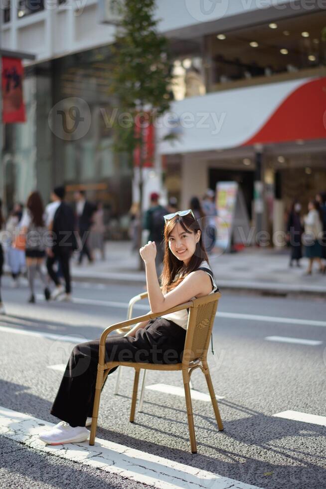 Tokyo's urban charm, a chic asian woman on a bench, embodying the beauty of city life. photo