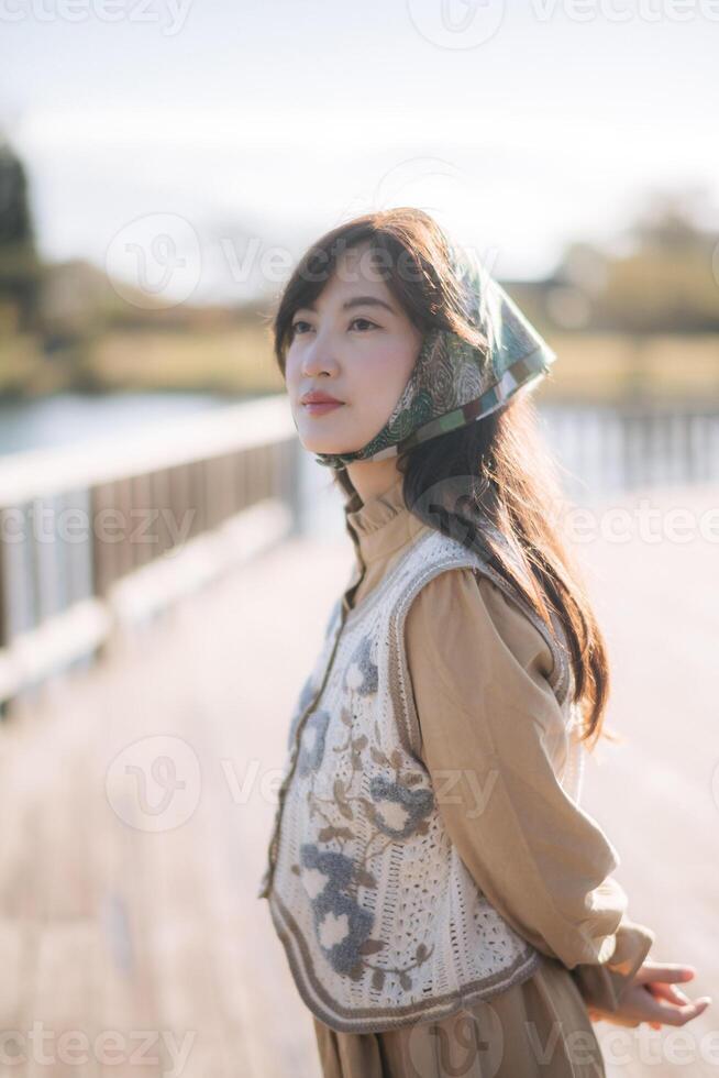 Sunny and cheerful, Portrait of a young Asian woman enjoying a vacation in Japan. Stylish and pretty, capturing the refreshing and relaxed vibes amidst the beauty of nature. photo