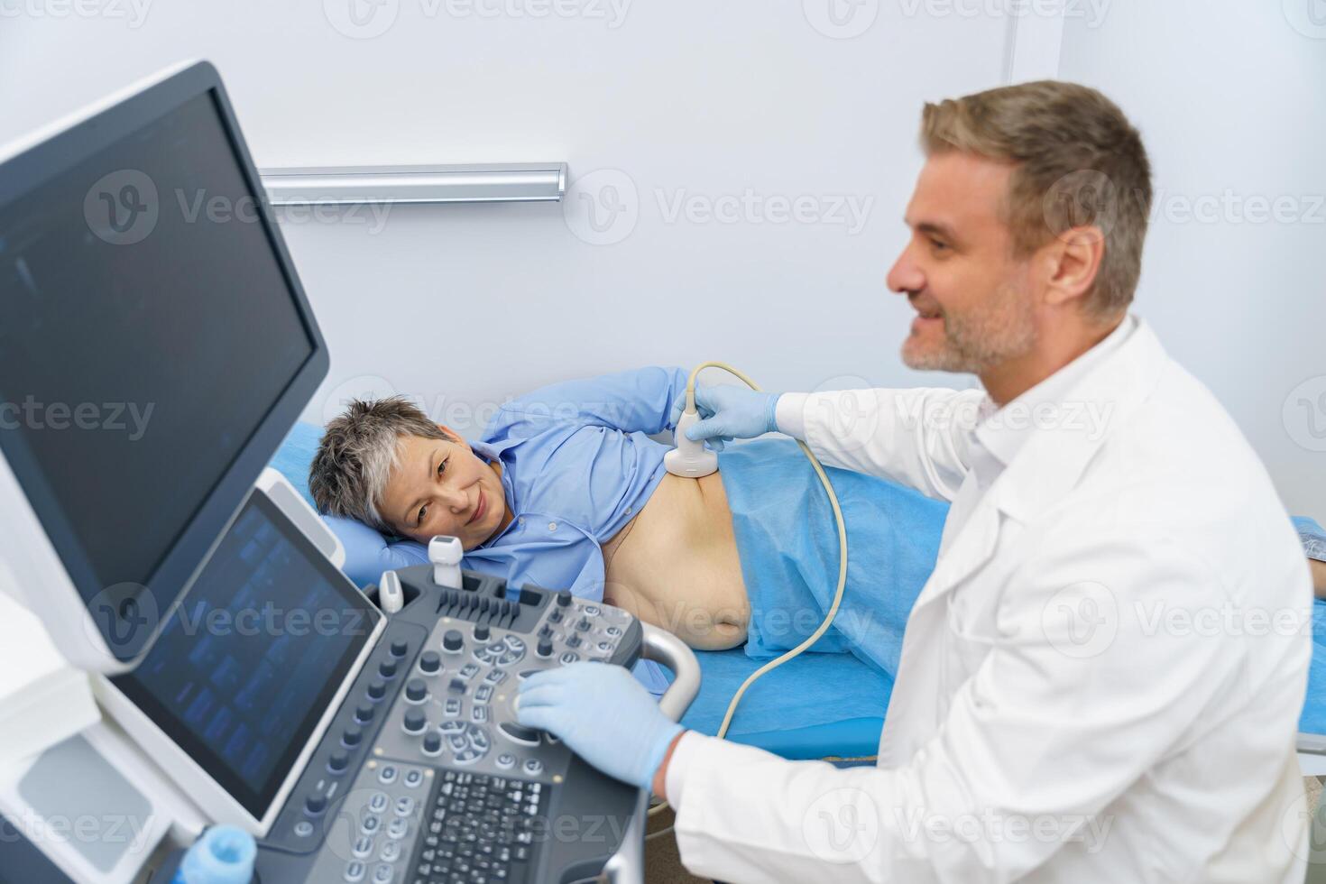Middle aged woman patient during ultrasound examination of thyroid lying on couch in medical office photo