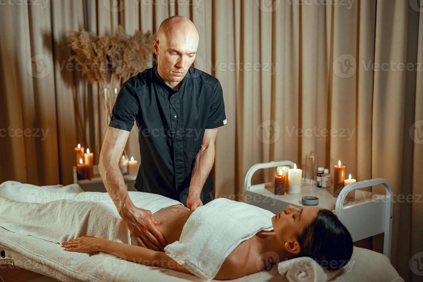 Alternative medicine spa salon therapist doing massage to woman lying on a daybed photo