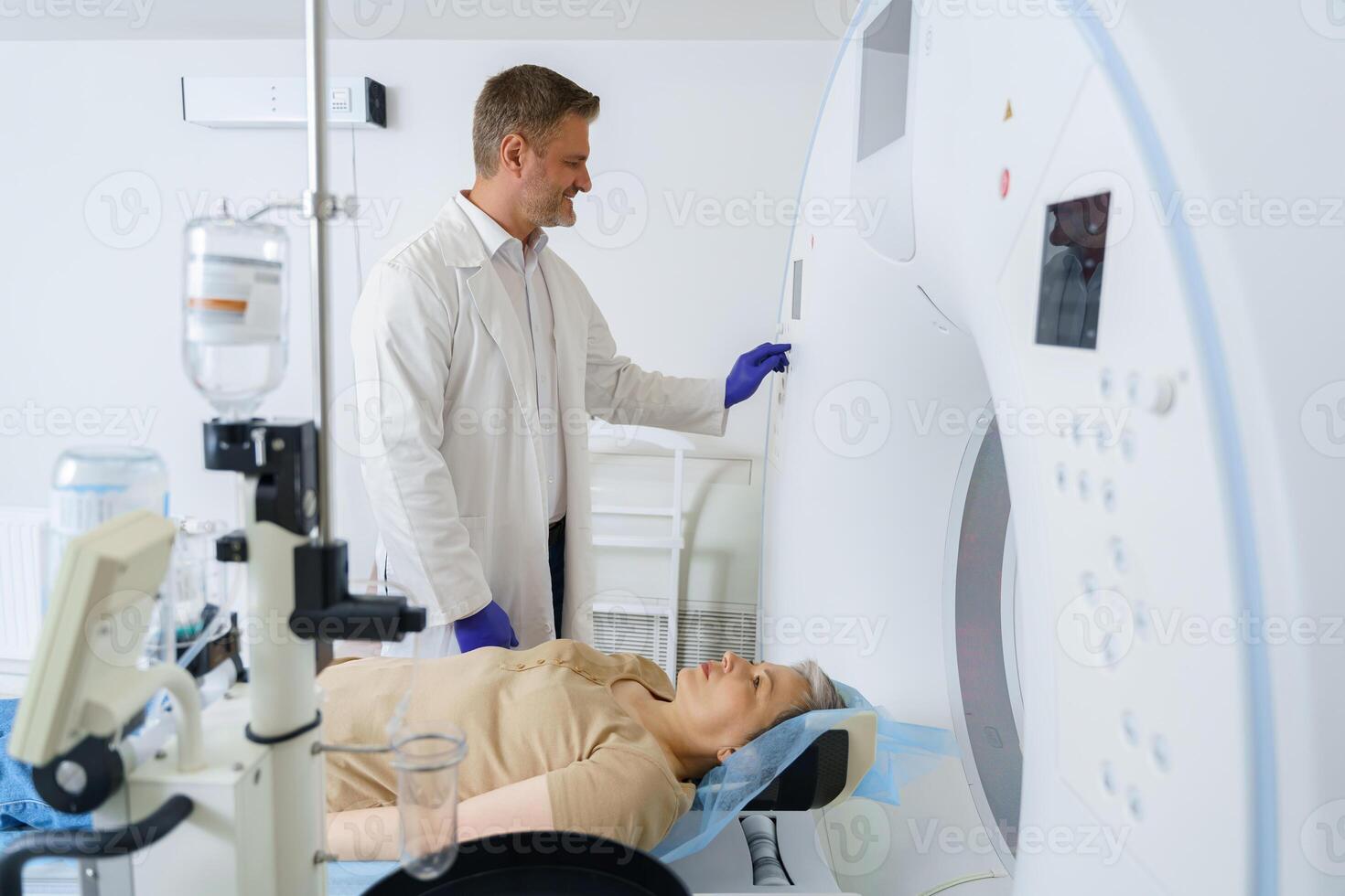 Doctor radiologist pushing button on panel to start mri scan procedure for female patient photo