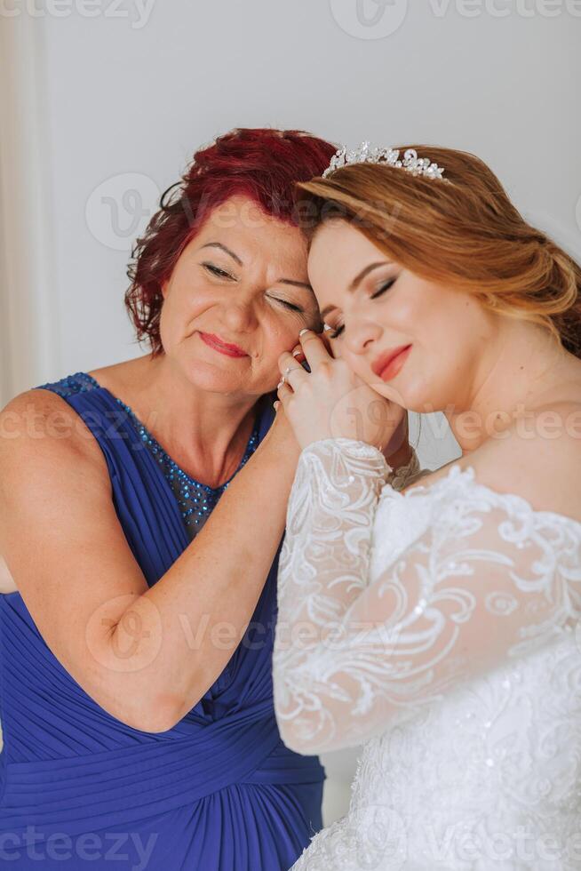 A woman is getting her ears pierced by her mother photo