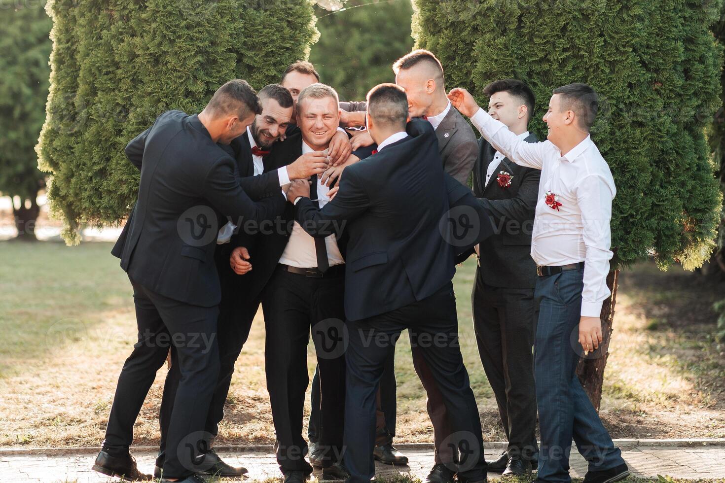 A group of men are standing in a circle, some of them are wearing suits photo