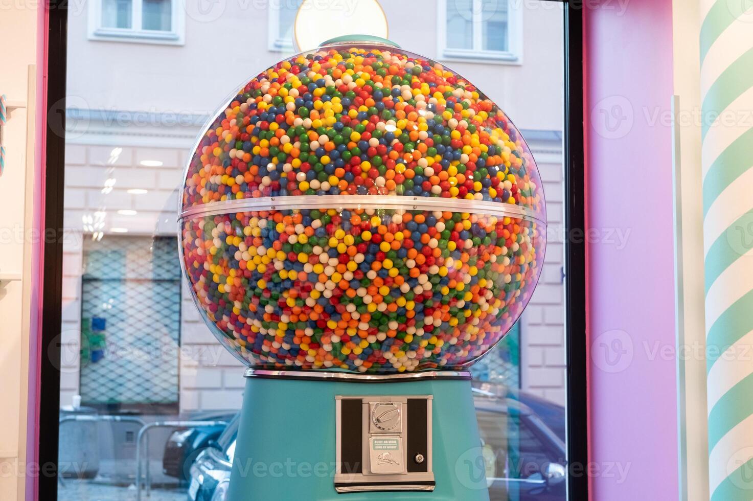 Giant gumball machine filled with colorful gumballs inside a candy store. photo