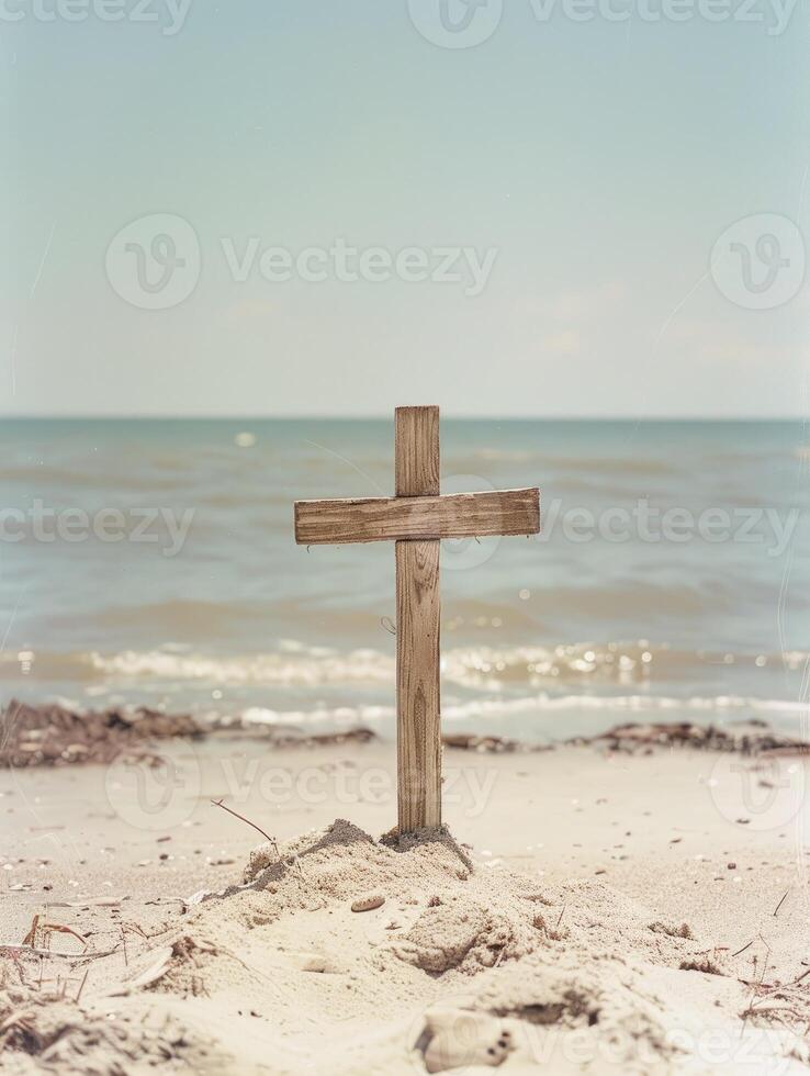 A wooden cross on the beach with blue sea and sky background photo