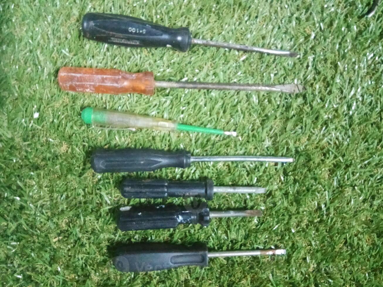 set of screwdrivers on grass photo