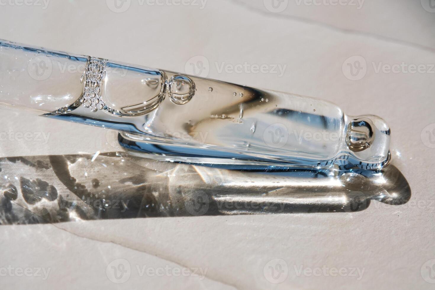 Pipette with serum on a beige background. photo