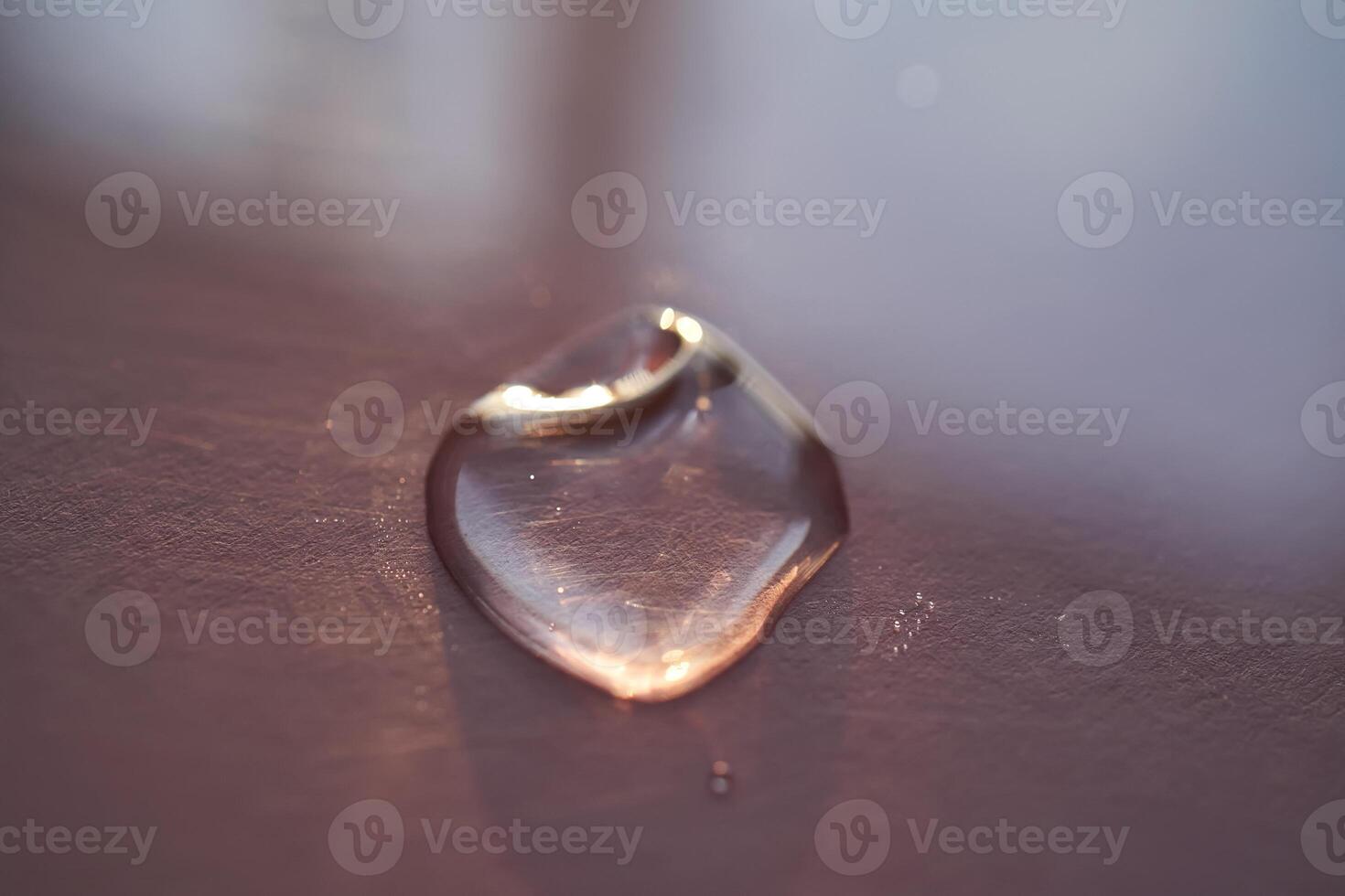 Beautiful volumetric drop of cosmetic product on a dark purple background. photo