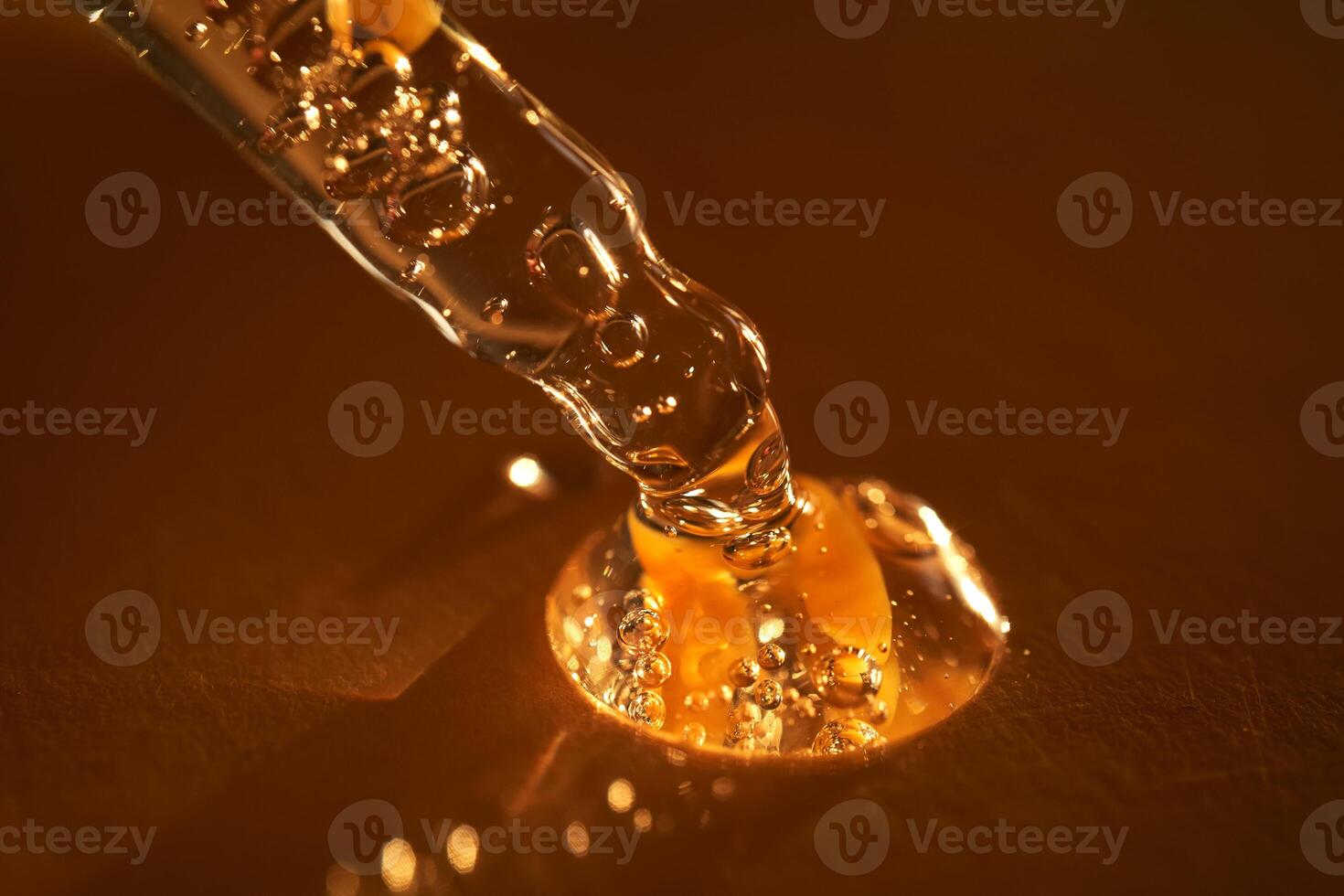 Pipette with serum shimmering in the sun on a beige background. photo