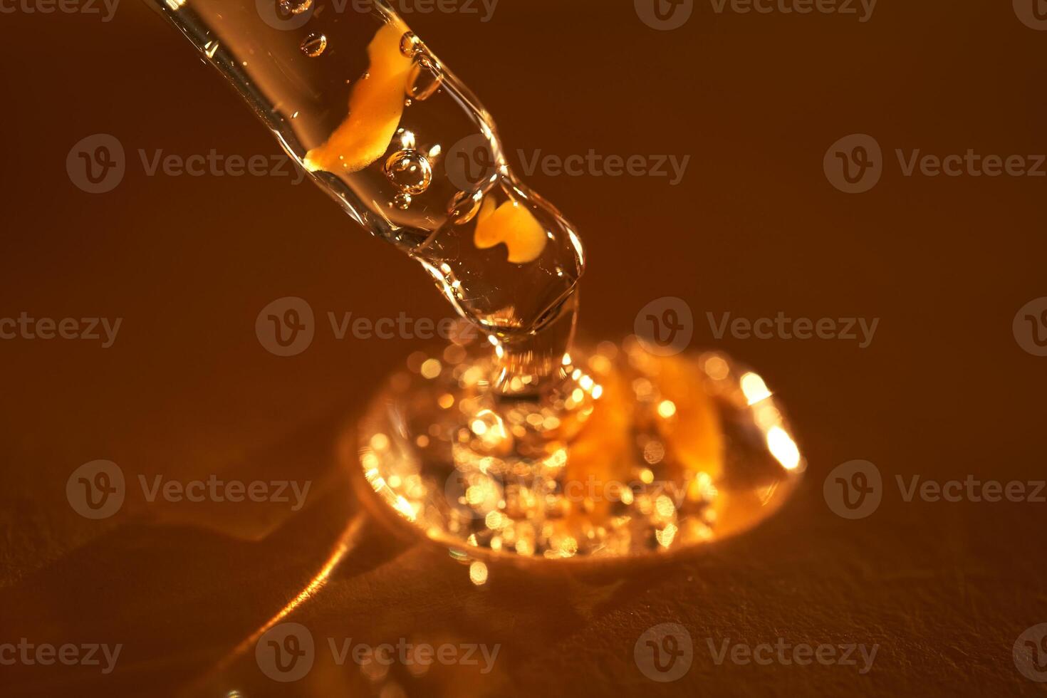 Pipette with serum shimmering in the sun on a beige background. photo