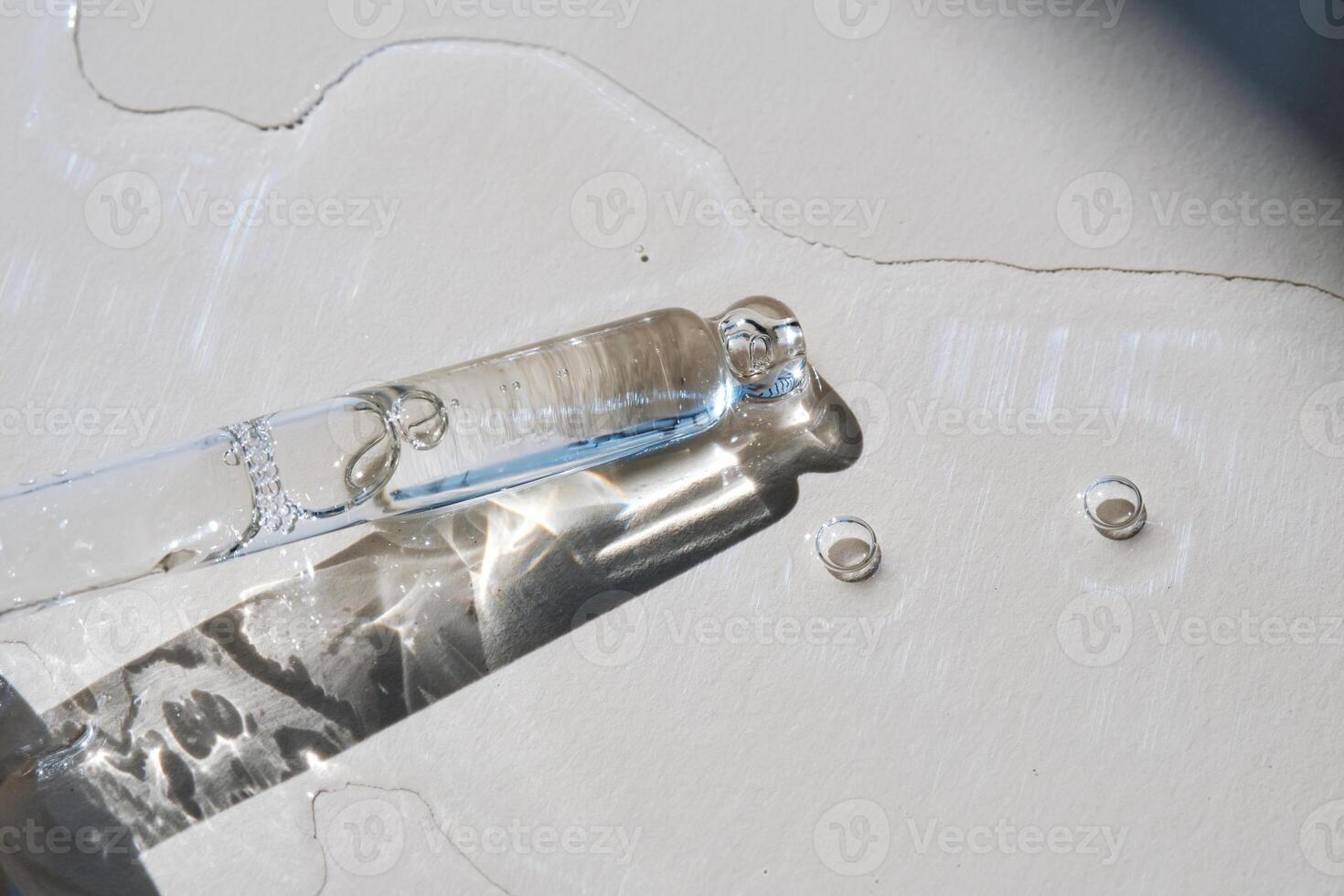 Pipette with serum on a beige background. photo
