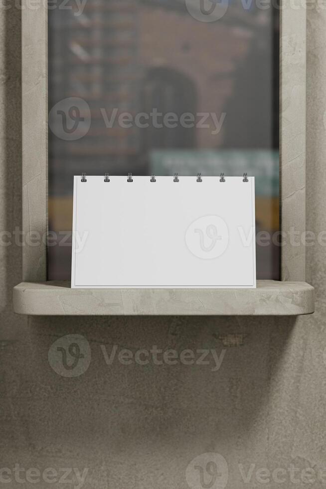 A blank calendar on a shelf in a window photo
